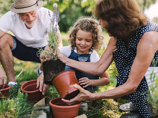portrait of grandparents gardening with their granddaughter retire smart